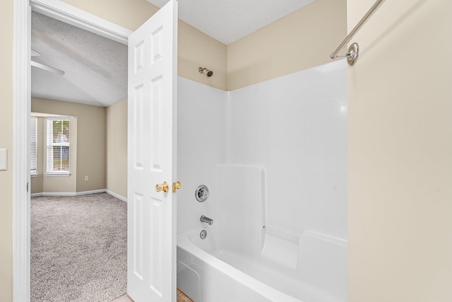 bathroom featuring washtub / shower combination and a textured ceiling