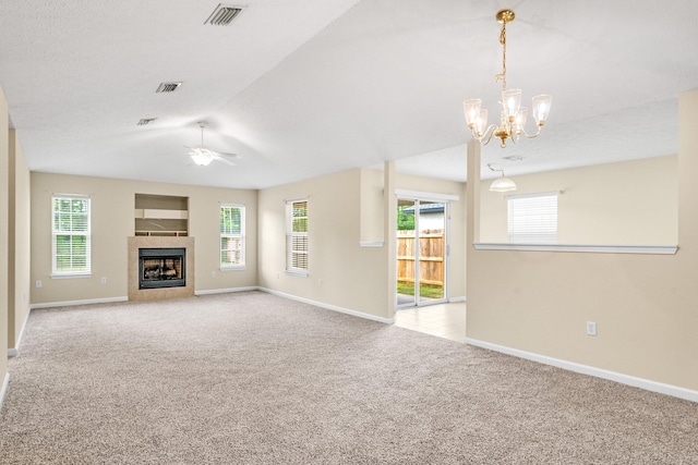 unfurnished living room featuring light colored carpet, plenty of natural light, and a tile fireplace