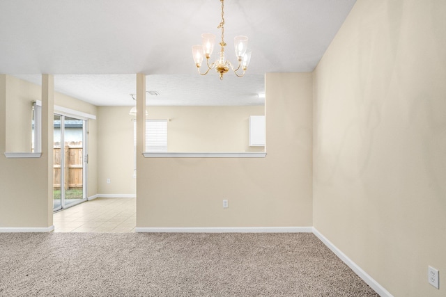 unfurnished room featuring an inviting chandelier and light colored carpet