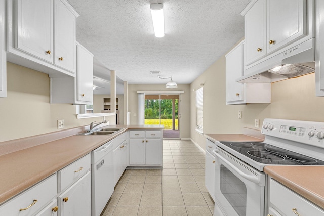 kitchen featuring sink, light tile patterned floors, kitchen peninsula, white appliances, and white cabinets