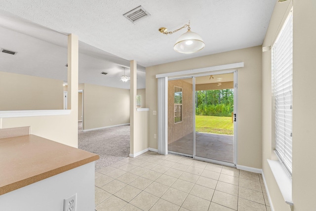 interior space featuring light tile patterned floors and a textured ceiling