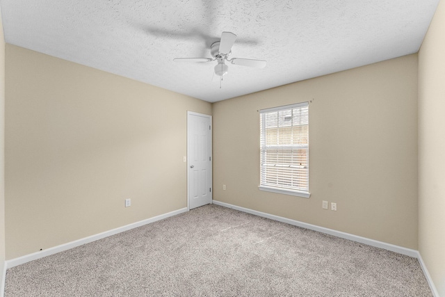 carpeted empty room with a textured ceiling and ceiling fan