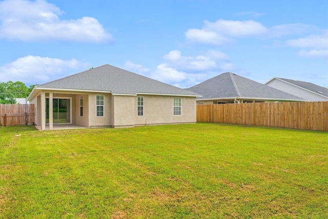 rear view of house with a patio and a lawn