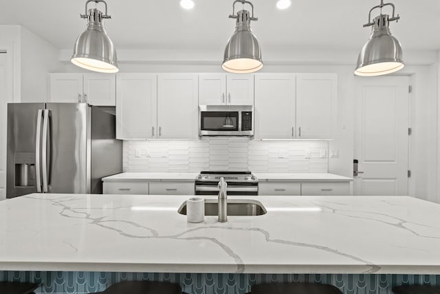 kitchen featuring appliances with stainless steel finishes, backsplash, and light stone countertops