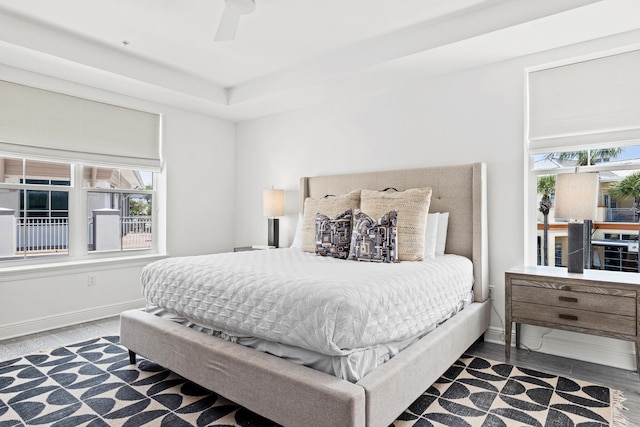 bedroom with ceiling fan, hardwood / wood-style flooring, and multiple windows