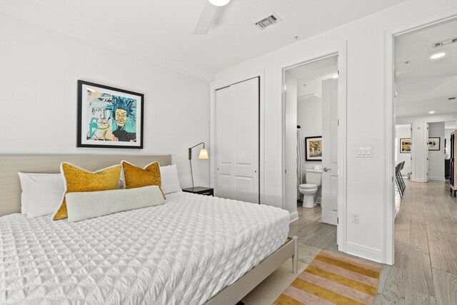 bedroom with ensuite bathroom, a closet, ceiling fan, and light hardwood / wood-style floors