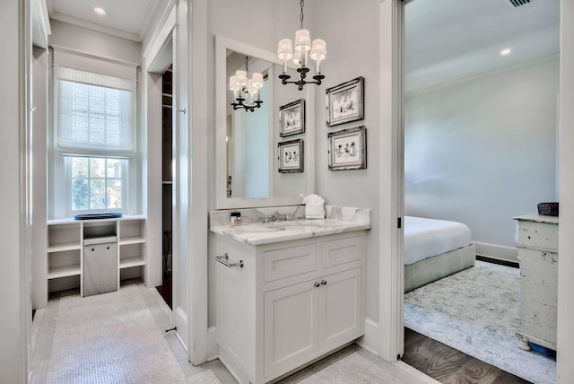 bathroom with crown molding, vanity, a notable chandelier, and wood-type flooring