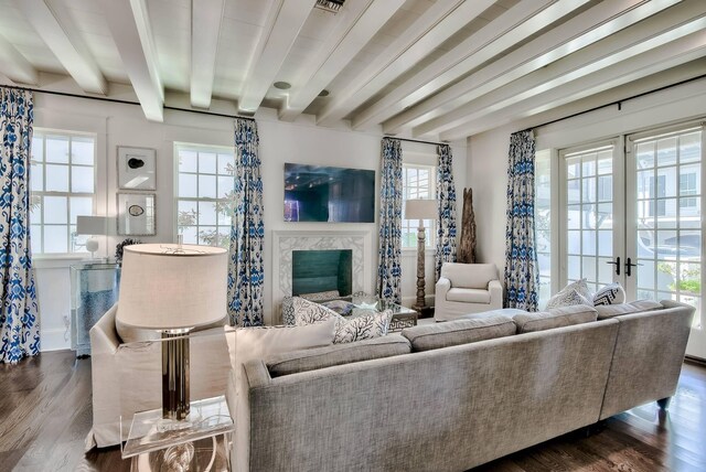 living room with hardwood / wood-style floors, beam ceiling, a high end fireplace, and french doors