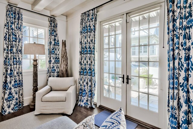 interior space with plenty of natural light, beam ceiling, and dark hardwood / wood-style floors