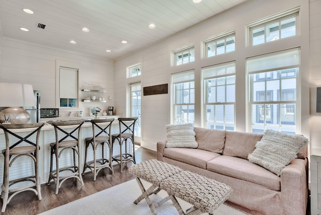 living room featuring crown molding, a wealth of natural light, and dark hardwood / wood-style floors