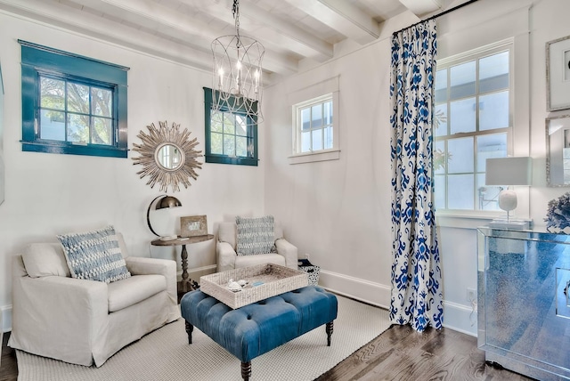 living area featuring plenty of natural light, hardwood / wood-style floors, beam ceiling, and a notable chandelier