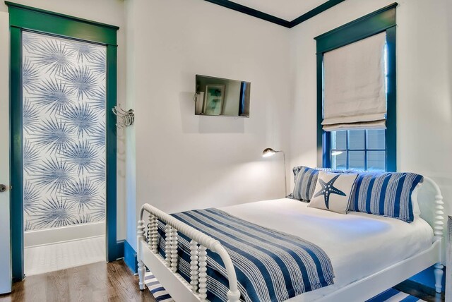 bedroom with crown molding and wood-type flooring