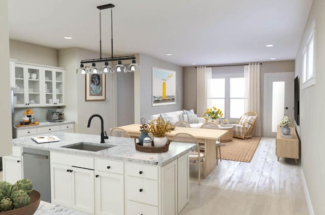 kitchen with glass insert cabinets, open floor plan, white cabinetry, and a sink