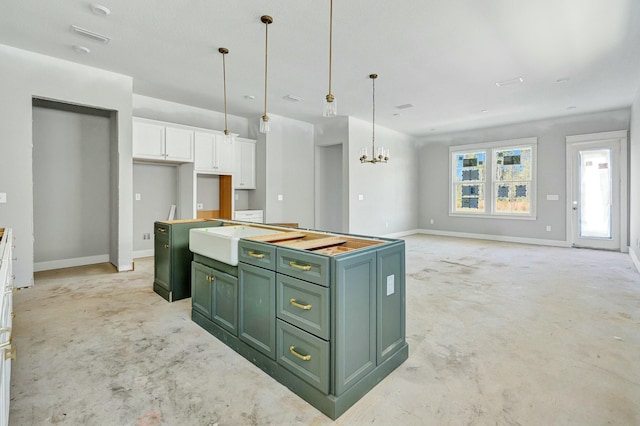 kitchen with a chandelier, white cabinetry, baseboards, a center island, and green cabinetry