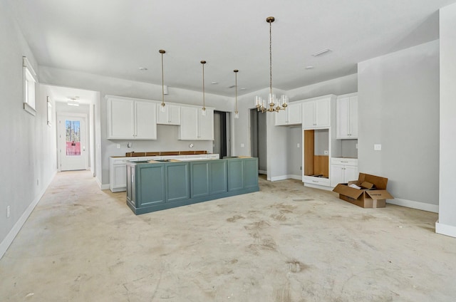 kitchen featuring unfinished concrete floors, baseboards, white cabinets, and a center island