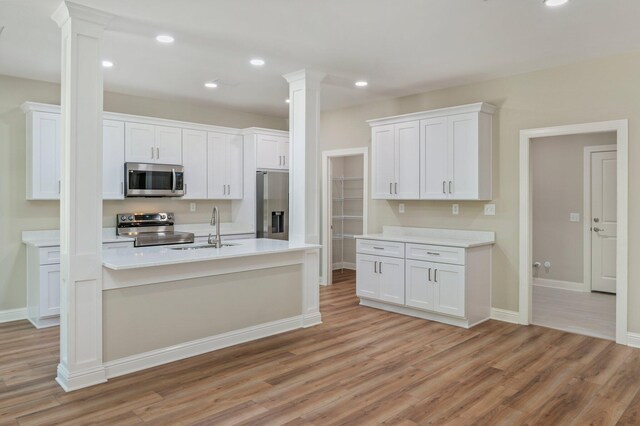 kitchen with white cabinetry, light hardwood / wood-style flooring, and appliances with stainless steel finishes