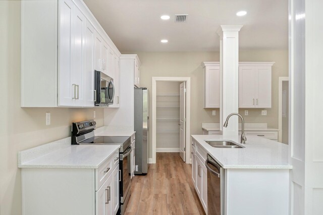 kitchen featuring light hardwood / wood-style floors, appliances with stainless steel finishes, sink, and white cabinetry