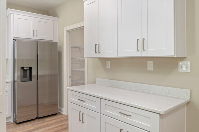 kitchen featuring light hardwood / wood-style flooring, stainless steel fridge with ice dispenser, and white cabinetry