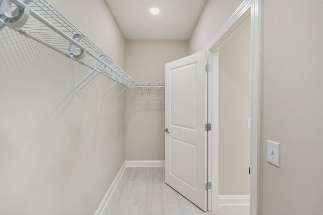 walk in closet with light tile patterned floors