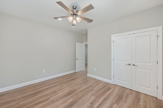 unfurnished bedroom with light hardwood / wood-style floors, ceiling fan, and a closet