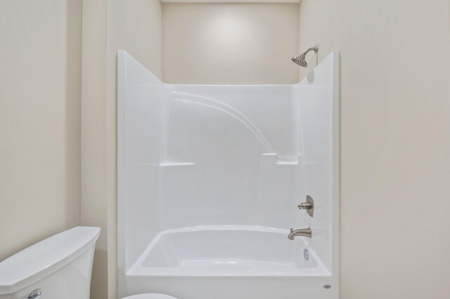 bathroom with bathing tub / shower combination and toilet