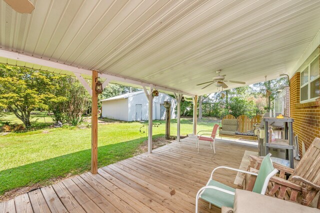 deck featuring ceiling fan, a storage shed, and a lawn