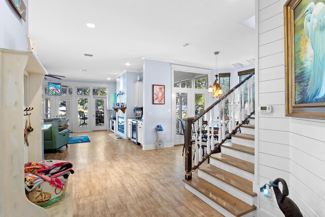 foyer entrance featuring plenty of natural light, light hardwood / wood-style flooring, french doors, and ornamental molding