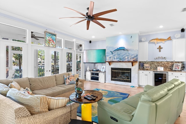 living area with a wealth of natural light, wine cooler, french doors, and crown molding