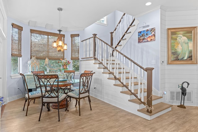 dining area featuring a notable chandelier, light hardwood / wood-style flooring, and ornamental molding