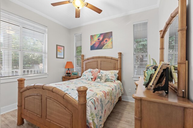 bedroom with ceiling fan, light wood-type flooring, and crown molding