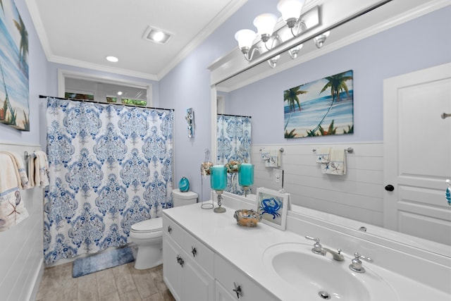 bathroom with wainscoting, toilet, wood finished floors, crown molding, and vanity