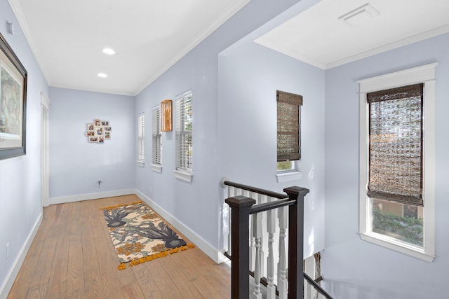 corridor featuring light wood-type flooring and ornamental molding