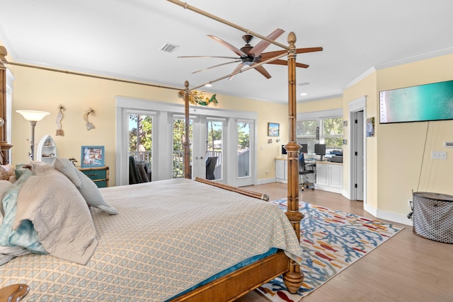 bedroom with visible vents, baseboards, wood finished floors, access to exterior, and crown molding