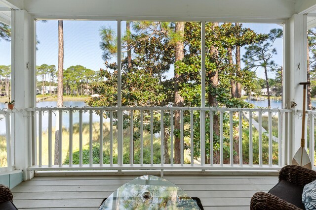 sunroom / solarium featuring a water view