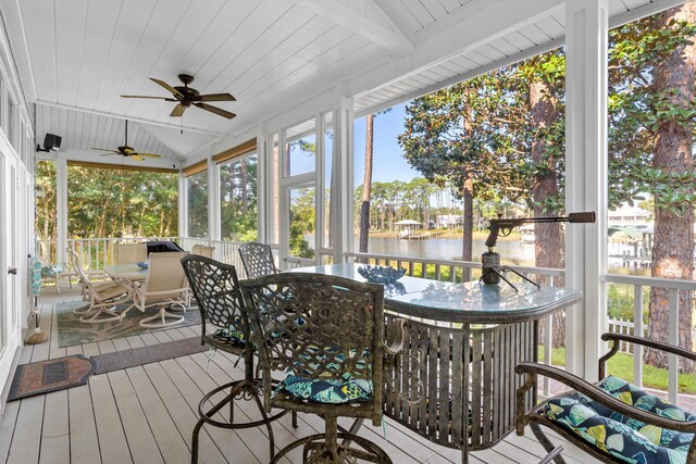 sunroom / solarium with ceiling fan, a water view, and lofted ceiling with beams