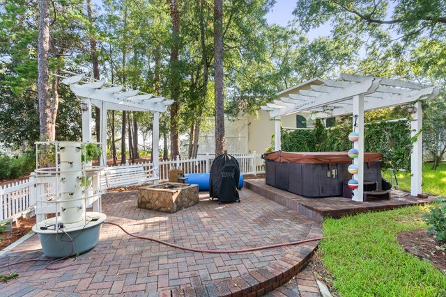 view of patio / terrace featuring a pergola, a hot tub, and a fire pit