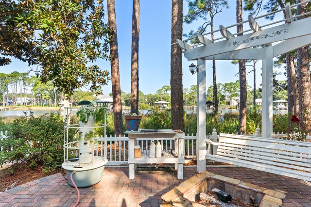 view of patio / terrace featuring a pergola and a water view