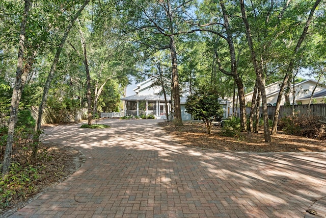 view of front facade featuring decorative driveway and fence