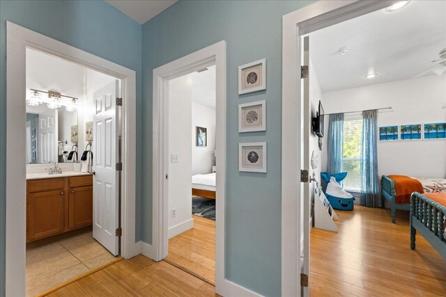 hallway with sink and light hardwood / wood-style flooring