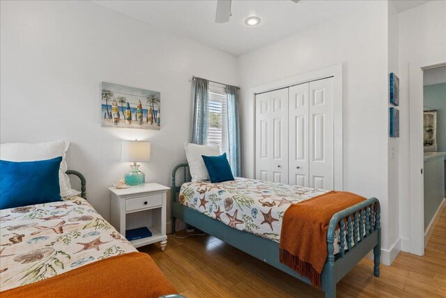 bedroom with hardwood / wood-style floors, a closet, and ceiling fan