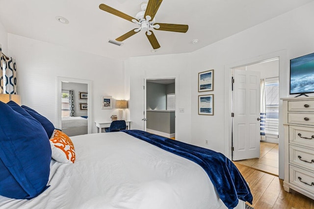 bedroom featuring ceiling fan, connected bathroom, and light hardwood / wood-style flooring