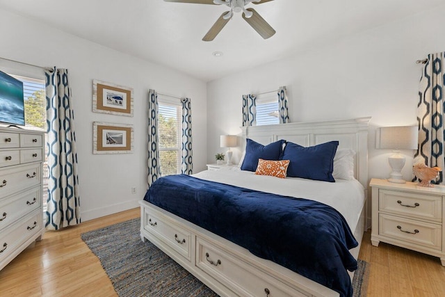 bedroom with multiple windows, light hardwood / wood-style flooring, and ceiling fan