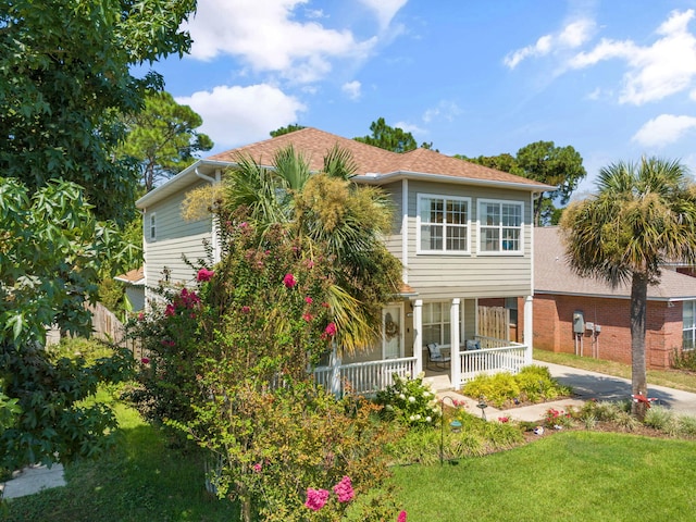 rear view of property with a yard and covered porch