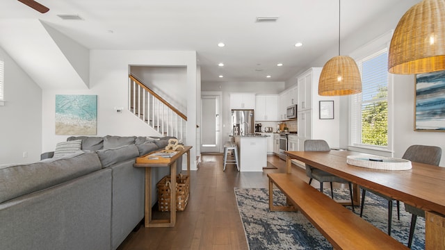 dining area with ceiling fan and dark wood-type flooring