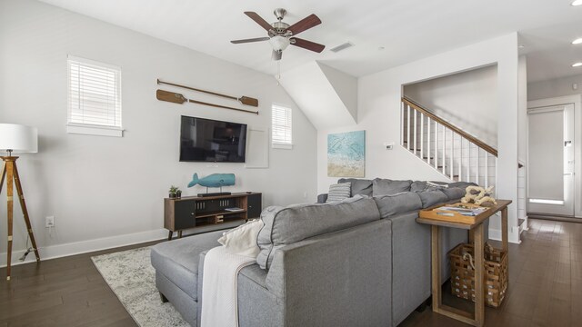 living room with ceiling fan, vaulted ceiling, and dark wood-type flooring