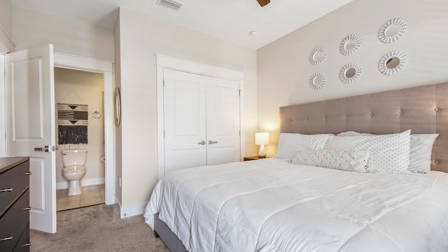 bedroom featuring ceiling fan, connected bathroom, a closet, and light carpet