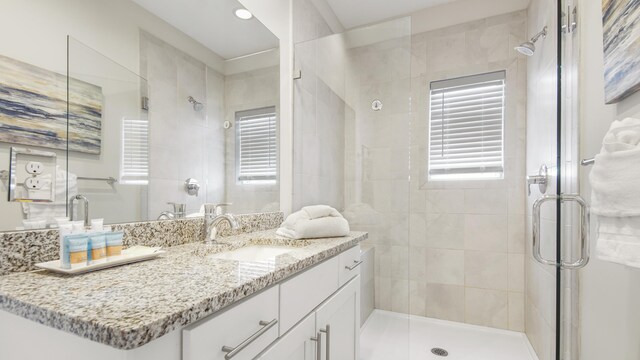 bathroom featuring a wealth of natural light, vanity, and a shower with shower door