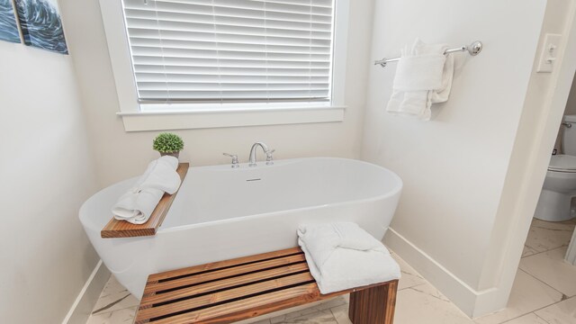 bathroom featuring tile patterned floors, a bathtub, and toilet