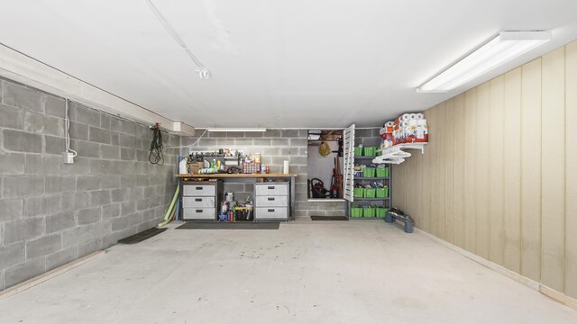 basement featuring a workshop area and wooden walls