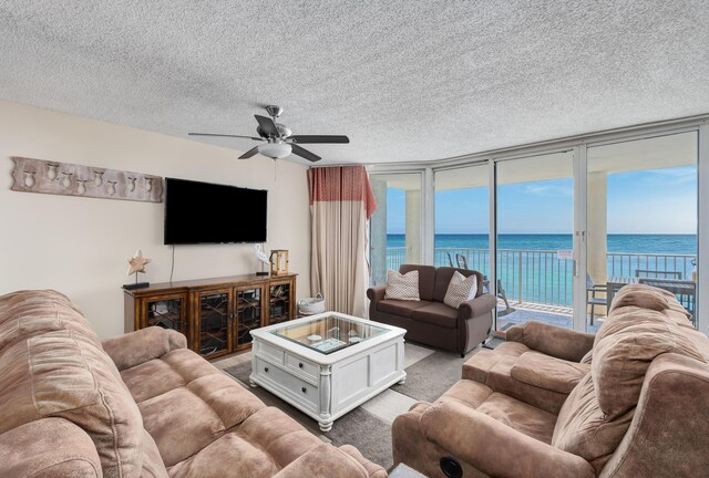 living room with ceiling fan, light carpet, a textured ceiling, and a wealth of natural light